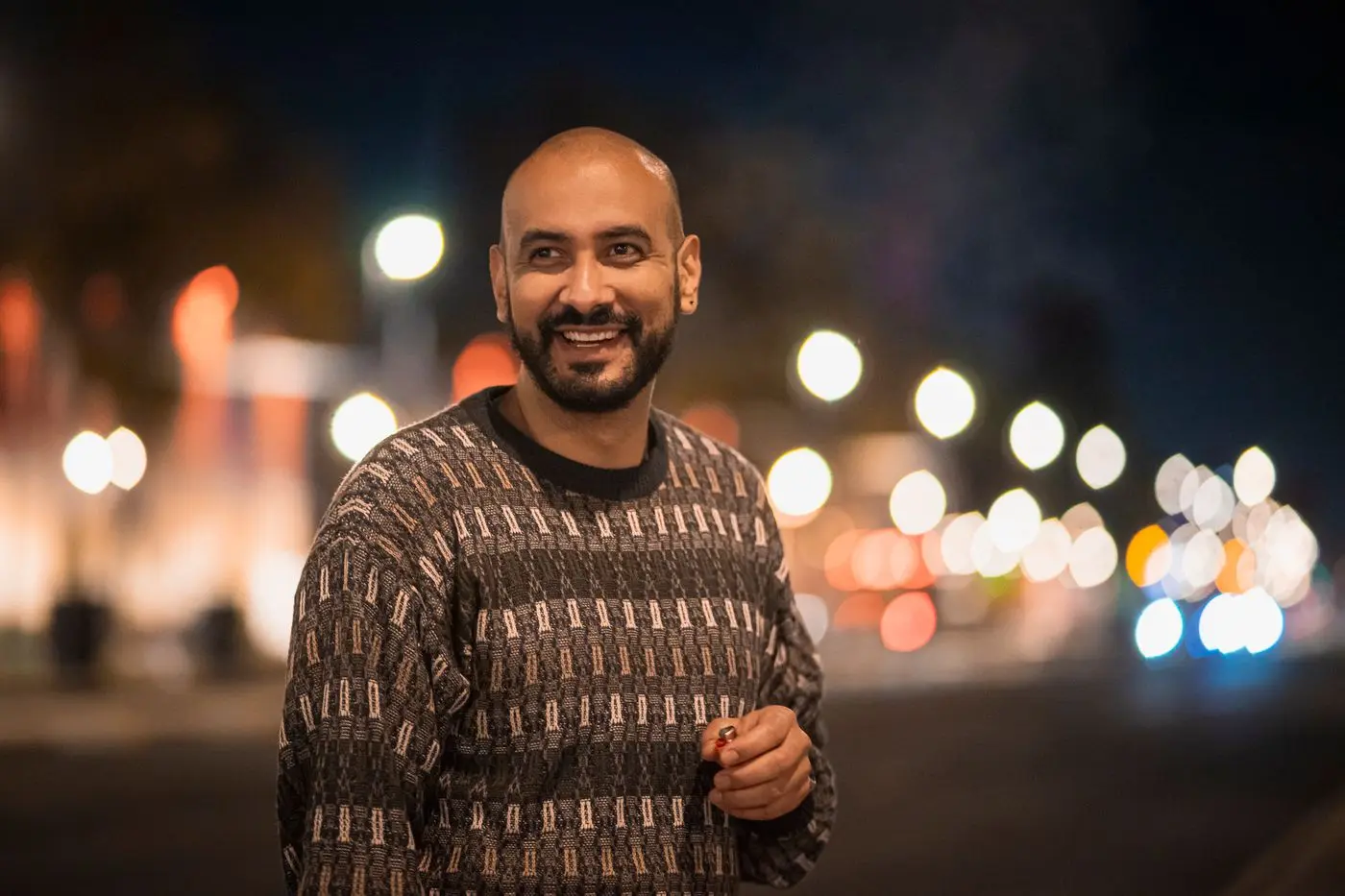Hombre sonriendo en una calle de la Ciudad de México de noche